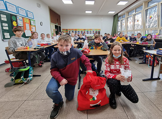 Klassenzimmer mit Kindern, welche Nikolausgeschenke erhalten haben